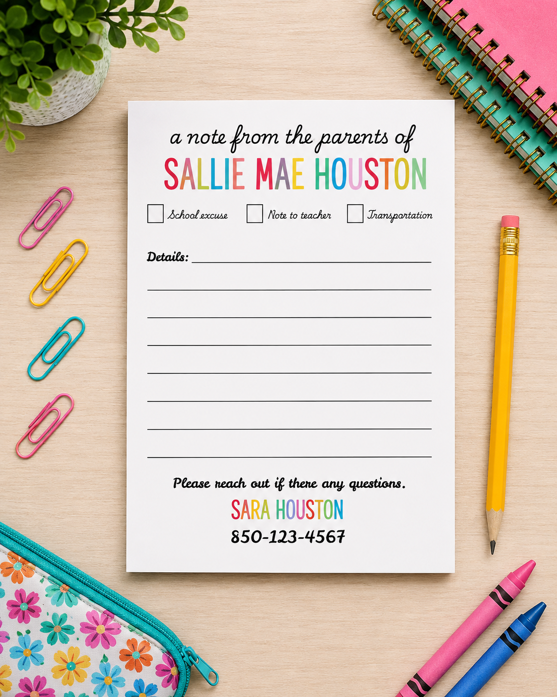 A printed note notepad from the parents of Sallie Mae Houston, styled in a flat-lay desk scene with a pencil, paper clips, notebooks, crayons, and a floral pencil case on a light wood background.