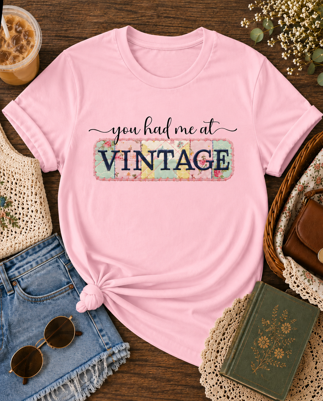 Light Pink Shirt with “You Had Me at Vintage” graphic tee styled in a cozy flat lay with iced coffee, denim shorts, sunglasses, crochet accessories, and vintage-inspired thrifted finds.
